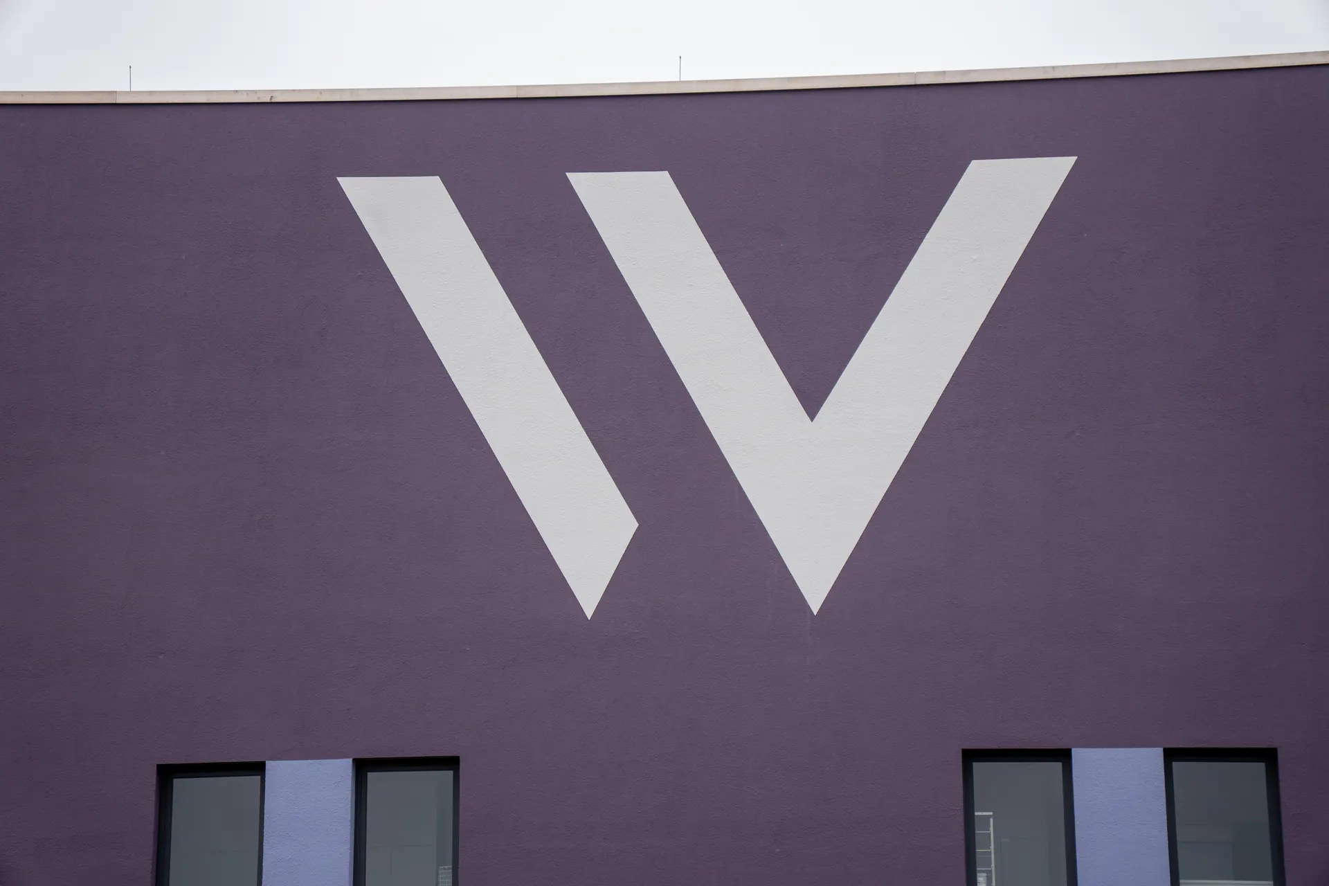 Large white W on the purple façade of the Weight Doctors® Nationalklinik in Wertheim