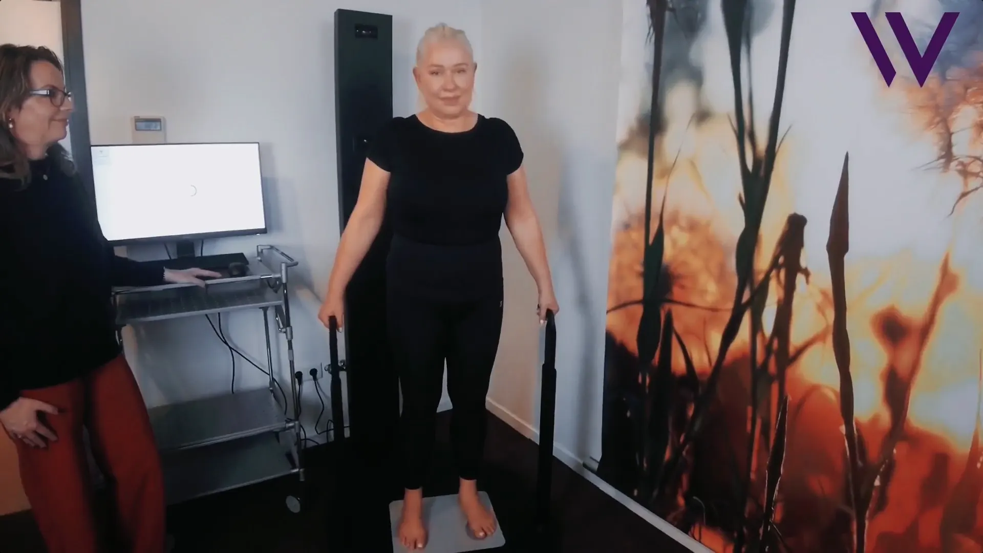 Patiënte bij de 3D Bodyscan, daarnaast een medewerkster achter het beeldscherm